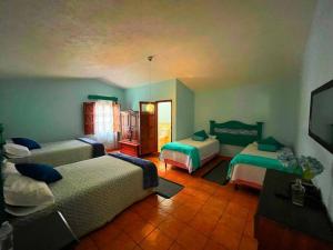 a bedroom with two beds and a television in it at CasaDe Leon-Hotel Boutique in Antigua Guatemala