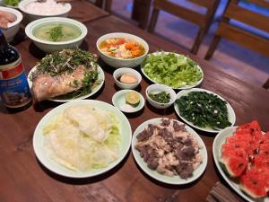 un tavolo in legno con piatti di cibo sopra di Lagom Su Phi Retreat a Hoàng Su Phì