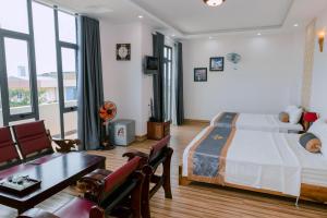 a bedroom with a bed and a living room at Khách sạn Hoàng My in Liên Trì (3)