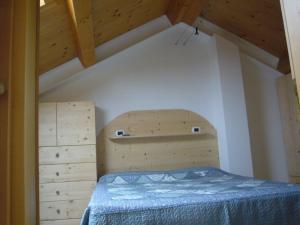 a small bedroom with a bed and wooden ceilings at Case Pizzocco 3 a Santa Giustina in Meano