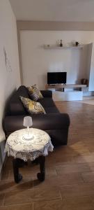 uma sala de estar com um sofá preto e uma mesa em La Casa di Trilly em Cerveteri