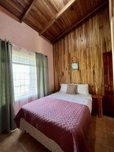 ein Schlafzimmer mit einem Bett in einem Zimmer mit einem Fenster in der Unterkunft Beautiful Casa Aire near Lake Arenal in Nuevo Arenal - Casas Airelibre in Nuevo Arenal