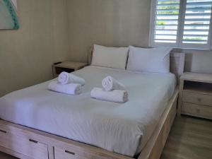 Byron Bay Beachfront Apartments في خليج بايرون: غرفة نوم عليها سرير وفوط