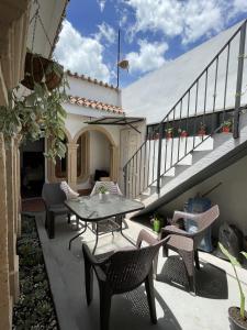 a patio with a table and chairs and stairs at Zoola Suites Antigua in Antigua Guatemala