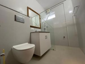 a white bathroom with a toilet and a shower at Daffodils Luxury Airport Suites in Cochin