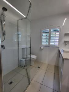 a bathroom with a glass shower and a toilet at Byron Bay Beachfront Apartments in Byron Bay