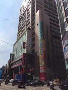 un edificio alto en una ciudad con tráfico y coches en i hotel 中壢館 en Zhongli