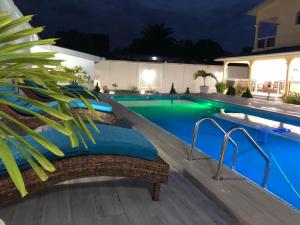 - une piscine d'eau bleue la nuit dans l'établissement villa piscine timbamba, à Pointe-Noire