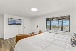 Un dormitorio con una gran cama blanca y una ventana en Venture at Route 66 en Flagstaff