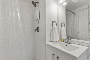 a white bathroom with a sink and a shower at Venture at Route 66 in Flagstaff