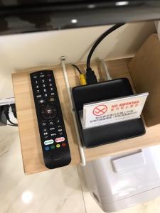 un mando a distancia sentado en un estante junto a una caja en 日日見宅 Matsuya en Huwei