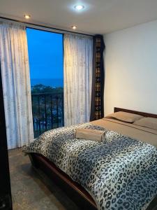 a bedroom with a leopard print bed and a large window at Punta Centinela Apartment in Punta Blanca