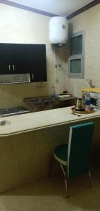 eine Küche mit einer Theke, einem Stuhl und einem Waschbecken in der Unterkunft Fully Equipped ,Private ,centrally located flat in Mohandsseen in Kairo