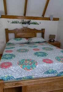 a bed with a quilt on it in a bedroom at Hermosa Cabaña en Isla Tierra Bomba. in Tierra Bomba