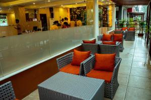 a row of chairs with orange pillows in a restaurant at Hotel Black Diamond - Inside Airport in Kathmandu