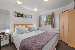 a bedroom with a large bed and a television at Lorenzo Motor Lodge in Christchurch