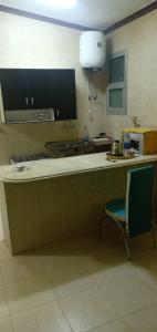 eine Küche mit einer Theke, einem Stuhl und einer Mikrowelle in der Unterkunft Fully Equipped ,Private ,centrally located flat in Mohandsseen in Kairo