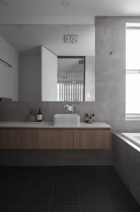 Baño blanco con lavabo y espejo en Treasure on Trestles - Premium Holiday Home hosted by Holiday Management, en Casuarina