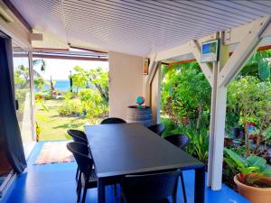 een tafel en stoelen in een kamer met uitzicht op de oceaan bij MOOREA - Fare Nihei in Maharepa