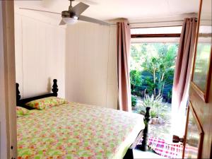 a bedroom with a bed and a large window at MOOREA - Fare Nihei in Maharepa