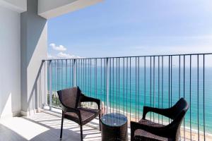 - un balcon avec deux chaises et une table donnant sur l'océan dans l'établissement Panorama Nha Trang Inn, à Nha Trang