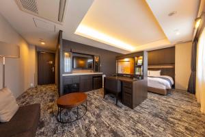 敦賀市にあるホテルグランビナリオ敦賀のベッドとデスクが備わるホテルルームです。