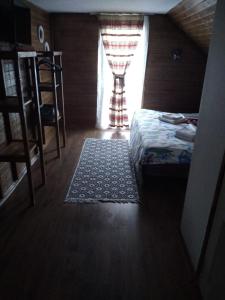 a bedroom with a bed and a window with a rug at CASA R&D in Moisei