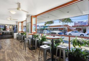 um restaurante com mesas e bancos em frente a uma janela em Penshurst Hotel em Sydney