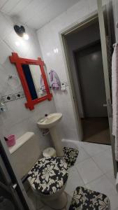 a bathroom with a toilet and a sink and a mirror at A Felicidade Mora Aqui!!!! in Novo Hamburgo