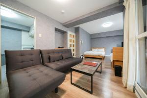 a living room with a couch and a bed at Residence Hotel KABUTO in Sapporo