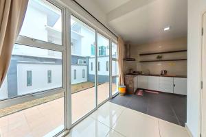 an empty room with large windows and a kitchen at Desaru Spacious 6 Rooms Bungalow 22paxes KTV-Billard-BBQ-Netflix in Kota Tinggi +21 photos