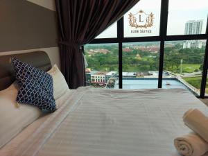 a hotel room with a bed with a large window at Luxe Suites at Skyloft in Johor Bahru
