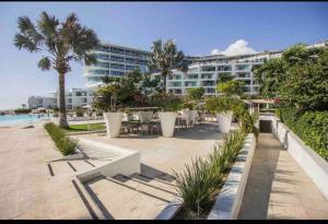 a resort with tables and chairs and a building at 313 Paraíso frente al mar in Nuevo Vallarta
