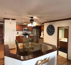 eine Küche mit einem Tisch und einer Uhr an der Wand in der Unterkunft Hamilton Cove Panoramic Ocean View Condo #2/32 in Avalon