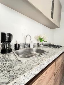 um balcão de cozinha com um lavatório de aço inoxidável em Apartamento 30min del Mar em Cartagena das Índias