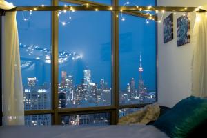 a bedroom with a window with a view of a city at Great View High Rise in Central Toronto in Toronto