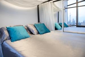 Sofá con almohadas azules en una habitación con ventana en Great View High Rise in Central Toronto en Toronto