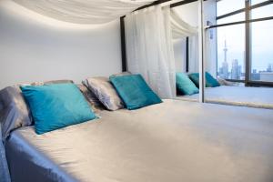 a couch with blue pillows in a room with a window at Great View High Rise in Central Toronto in Toronto