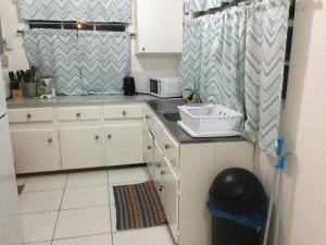 a small kitchen with white cabinets and a sink at Lorna's Cottage in Crown Point