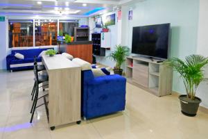Hostal Valle Andino في El Tambo: غرفة معيشة مع أريكة زرقاء وتلفزيون