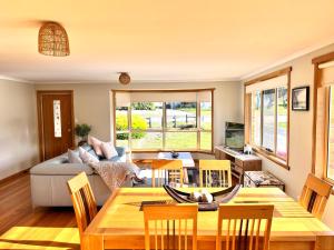 a living room with a table and chairs and a couch at The Hazards Beach Escape in Coles Bay