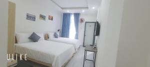 a hotel room with two beds and a television at Ánh Dương Homestay - Coastal stop - Just 2 mins walking to Eo Gio in Quy Nhon