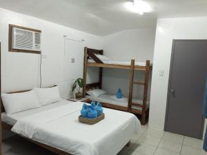 a room with two beds and a bunk bed at LALUNA COTTAGES in El Nido