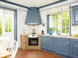 a kitchen with blue cabinets and a brick fireplace at Zollhaus in Kampen