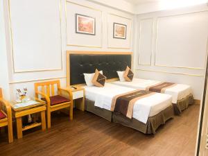 ein Hotelzimmer mit 2 Betten, einem Tisch und Stühlen in der Unterkunft Hotel Việt Mỹ in Hanoi