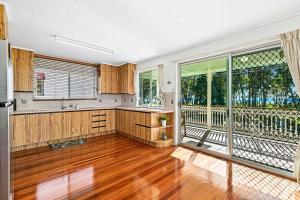 ToogoomOceanViews on Burrum Up的铺有木地板的空厨房以及阳台。 更多12张照片