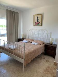 a bedroom with a white bed with two night stands and two lamps at Apartamento en Playa Nueva Romana in La Romana