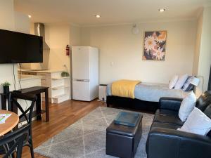 een kleine woonkamer met een bed en een bank bij March Apartments in Dunedin