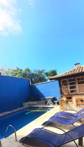 a resort with a swimming pool with blue walls at Pousada Beluga in Búzios