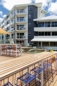 a deck with chairs and tables in front of a building at Ocean International Hotel in Mackay